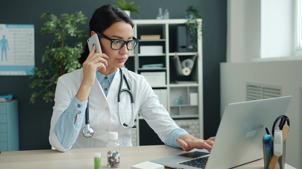 Marketing médico: médico no consultório usando laptop e celular
