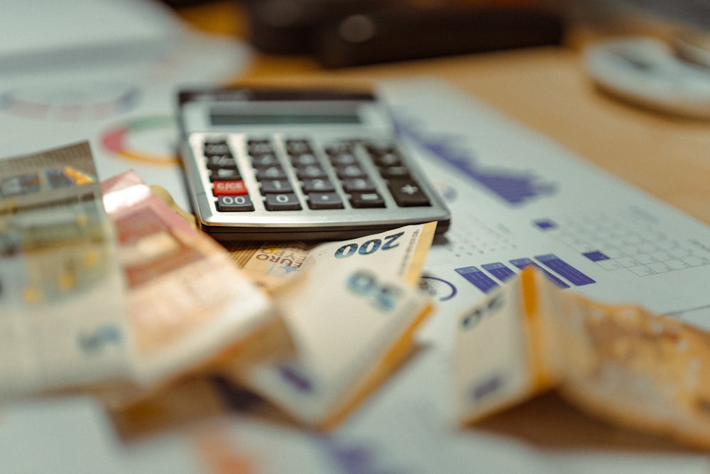 Calculadora sobre notas de dinheiro representando verba e honorário de tráfego pago