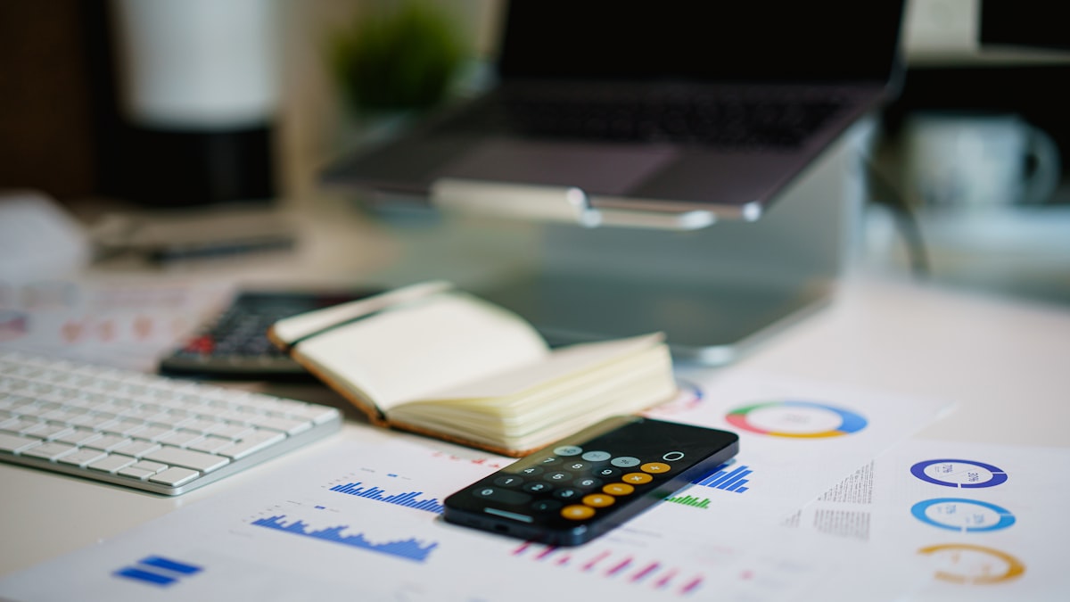 Mesa com gráficos financeiros e celular representando quanto custa tráfego pago